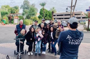 A group of people taking pictures with a man on the street.