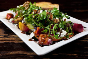 A plate of salad with dressing on top.