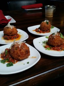 Four plates of food on a table with a napkin.