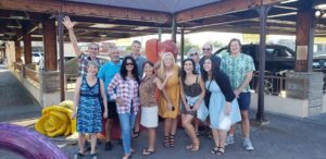 A group of people standing around in front of an outdoor structure.