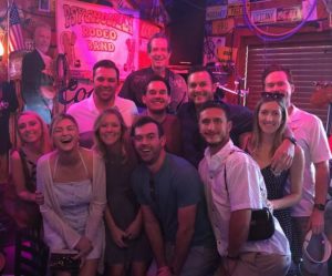 A group of people posing for a picture in front of a bar.